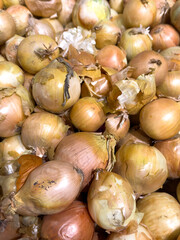 A pile of onions with some of them being rotten