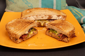 Country sandwich on a plate with toasted bread, cheese and ham