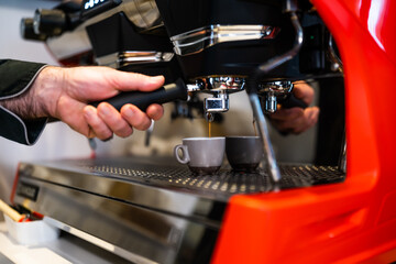 Close up of professional barista using coffee espresso machine.