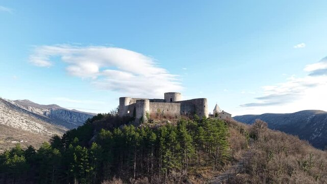 Drivenik Castle in the northern part of the Adriatic Sea, Croatia. The drone rises above the castle revealing a panoramic view of the Vinodolska dolina surrounded by high mountains 