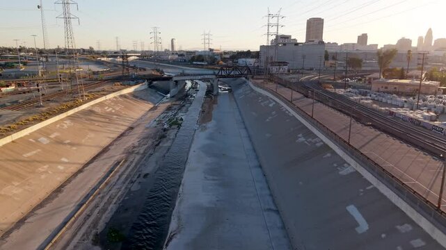 Los Angeles River in California, concrete to minimize erosion, flooding, and course change - aerial flyover at sunset