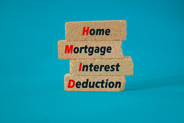 HMID Home mortgage interest deduction symbol. Brick blocks with words Home mortgage interest deduction on beautiful blue background. Business investment concept.