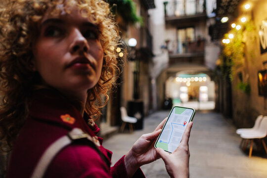 Woman checking directions on smart phone at city street