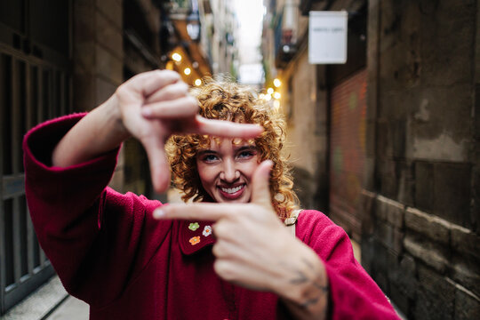 Smiling woman making finger frame