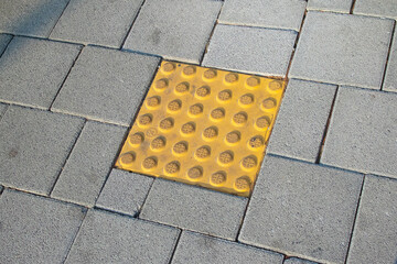 Tactile paving blocks and dotted blocks for the visually impaired on sidewalks in Korea.