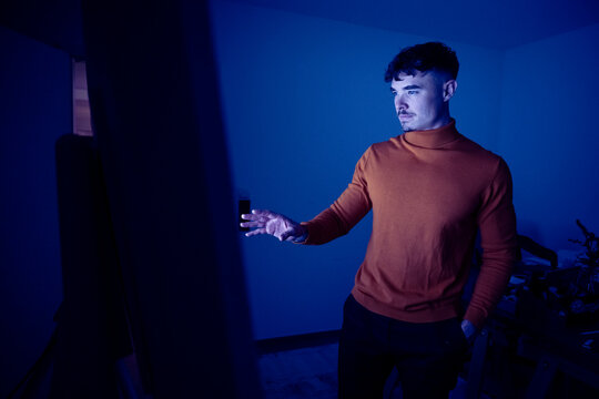 Man with hand in pocket standing and looking at digital screen in office