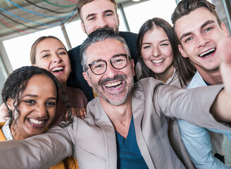Happy businessman taking selfie with colleagues in office