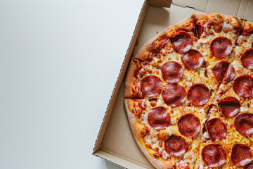 Pepperoni pizza in an open cardboard box on white background