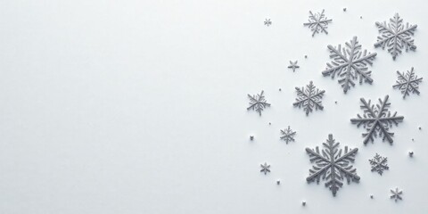Silver snowflakes scattered on a white background, creating a festive winter scene perfect for holiday cards or winter-themed designs.