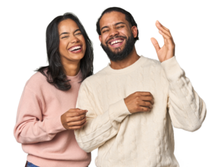 Young Latino couple in studio joyful laughing a lot. Happiness concept.
