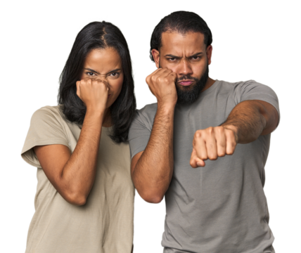 Young Latino couple in studio throwing a punch, anger, fighting due to an argument, boxing.