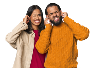 Young Latino couple in studio covering ears with fingers, stressed and desperate by a loudly ambient.