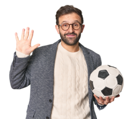 Hispanic male soccer coach in studio smiling cheerful showing number five with fingers.