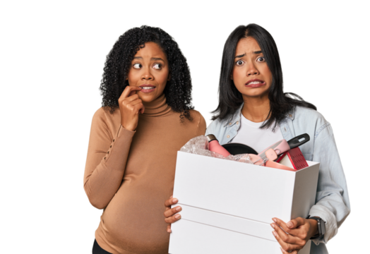 Latin women couple moving, one pregnant biting fingernails, nervous and very anxious.