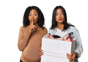 Latin women couple moving, one pregnant  keeping a secret or asking for silence.