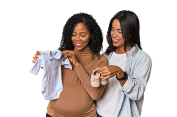 Two Latin women, one pregnant, holding baby shoes in studio