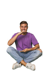 Obraz premium Casual man sitting on floor holding something with both hands, product presentation.