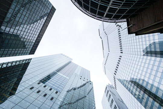 An upward view of towering glass structures, illustrating the magnificence of modern architecture and offering a sense of awe and inspiration amidst vibrant urban life in London UK