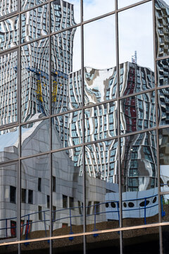 A mesmerizing view of distorted reflections on a glass building, showcasing the contrast between different architecture styles and forming an abstract urban landscape in London UK