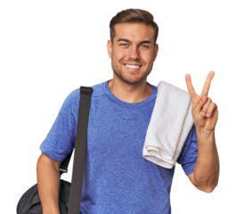 Athlete with gym bag, studio showing number two with fingers.