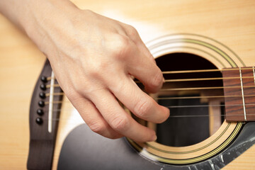 Hand Playing Acoustic Guitar Close-Up, wood fretboard detail, hand strumming acoustic guitar