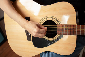 Hand Playing Acoustic Guitar Close-Up, studying fretboard details, performer playing melody