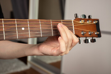 Hand Playing Acoustic Guitar Close-Up, musician teaching chords, education in music, skill of...