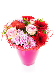 Bouquet with red and pink flowers and heart-shaped ornament in a vase, isolated