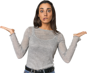 Hispanic young woman confused and doubtful shrugging shoulders to hold a copy space.