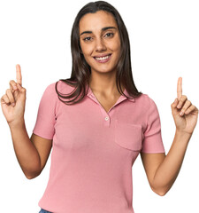 Hispanic young woman indicates with both fore fingers up showing a blank space.