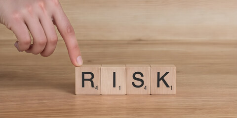 Risk Word on Wooden Tile Block.  business planning to reduce risk with information and decision making.