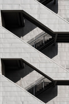 Featuring angular stairs against a minimalistic backdrop, the image captures intriguing shadow patterns that add depth and a sense of geometric spatial exploration.