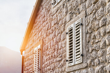 Stone wall of house with shutters
