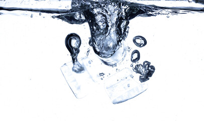 Splashing ice tubes scattered in water creating a dynamic air bubbles motion effect. Isolated white background. Ice tubes hit water create air bubbles clear drink