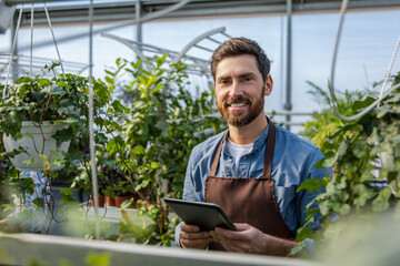 Male bearded greenhouse worker looking involved and busy