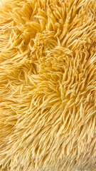 Close-up of soft yellow shaggy fur texture, featuring intricate fibers and vibrant color. Perfect for use as a background or textile design with warm and cozy aesthetics.