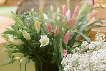 Beautiful bouquet of lilies in shop market illumed with warm sunrays