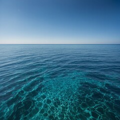 Obraz premium The image captures a serene scene of a vast blue ocean stretching towards the horizon under a clear blue sky. Gentle waves ripple across the water's surface, reflecting the vibrant hues of blue above.