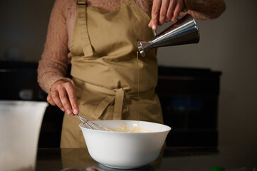 Preparation of batter in a mixing bowl with precise ingredient pouring