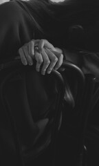 Black and White Close-Up of Hands Resting on a Chair Back, Expressing Tension and Thoughtfuln