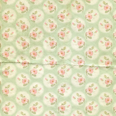 Vintage distressed floral pattern with pastel pink blossoms in circular frames on a soft green background, great for scrapbooking, wrapping paper, and retro textiles.