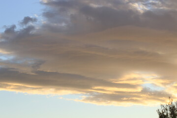 Fototapeta premium Sunset in the clouds. Fluffy clouds in the blue sky at sunset. A bunch of clouds. Beautiful sky at sunset. 