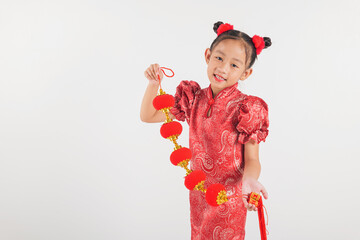 Chinese New Year. Happy Asian Chinese little kid girl smile wearing red cheongsam qipao holding silk lanterns on hand, Portrait children in traditional dress © sorapop