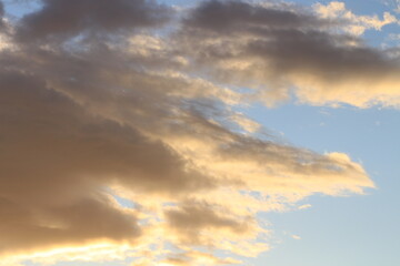 Obraz premium Sunset in the clouds. Fluffy clouds in the blue sky at sunset. A bunch of clouds. Beautiful sky at sunset. 