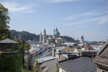 Fototapeta premium Exploring the rooftops of Salzburg, Austria, with a view of historical architecture and mountains in the background