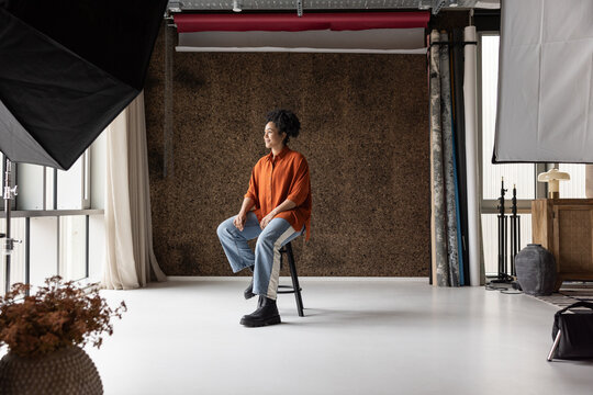 African American woman sitting in a photographic studio waiting to have her photo taken