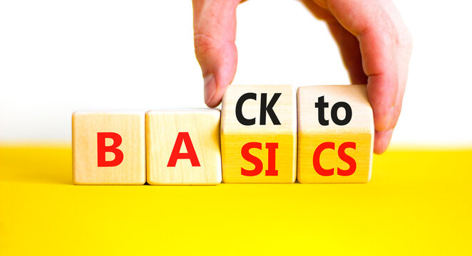 Back to basics symbol. Concept words Back to basics on wooden block. Beautiful yellow table white background. Businessman hand. Business back to basics concept. Copy space.