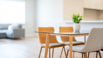 Fototapeta premium Modern dining area with a glass table, stylish chairs, and a potted plant, creating a bright atmosphere.