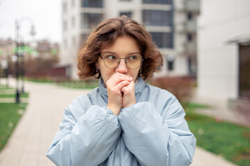 Fototapeta premium Freezing woman. A young beautiful frozen girl suffers from cold weather.