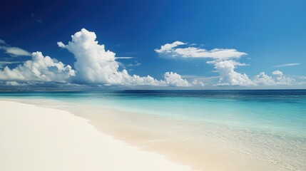 Obraz premium Serene beach landscape with pristine white sand and crystal clear turquoise waters under a bright blue sky with fluffy clouds
